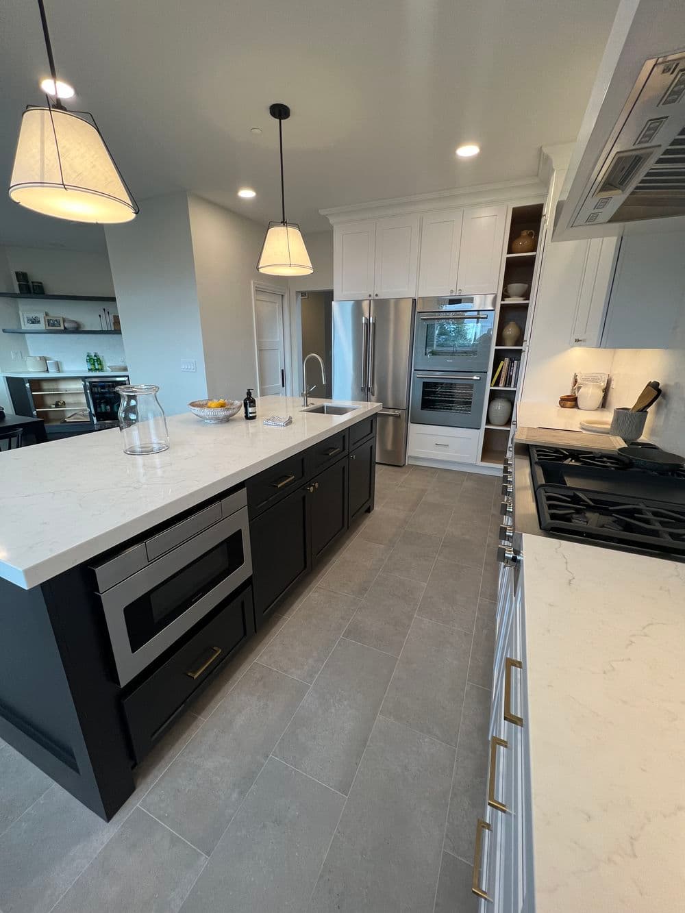 Modern kitchen with marble countertops, stainless steel appliances, and a spacious island.