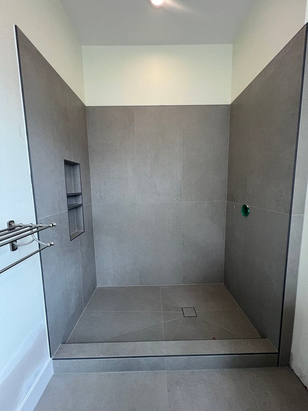 Modern shower design with gray tiles, built-in niche, and seamless entry.