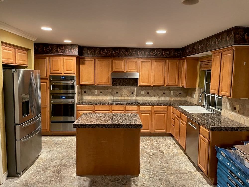 Modern kitchen with wooden cabinets, stainless steel appliances, and granite countertops.