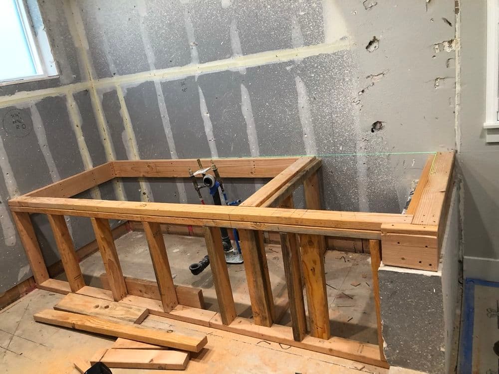 Wooden frame construction for a wall in a renovation project, tools and materials visible.