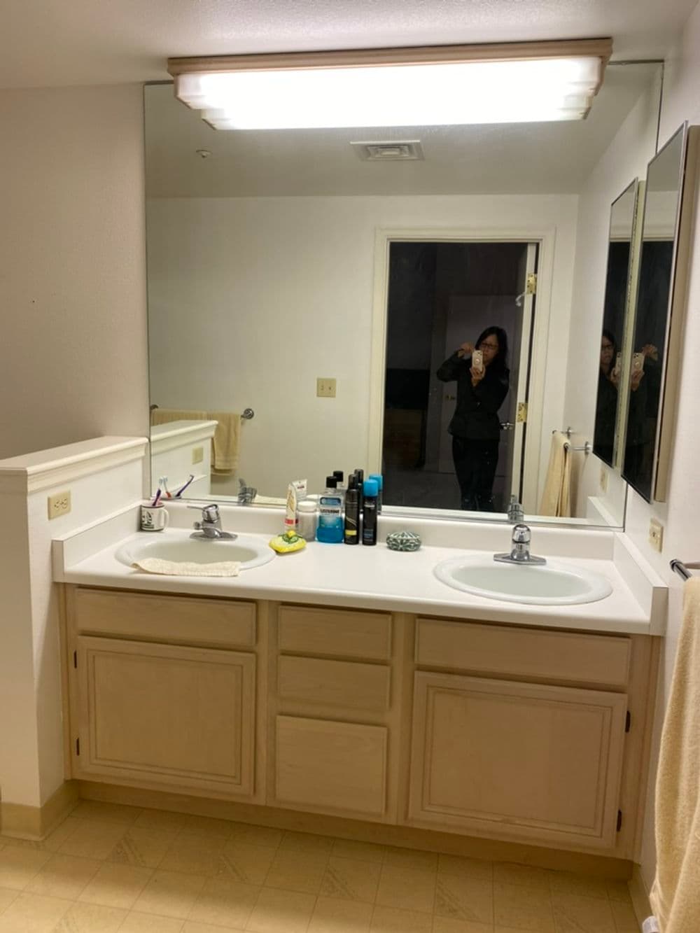 Modern bathroom vanity with double sinks, large mirror, and minimal decor.