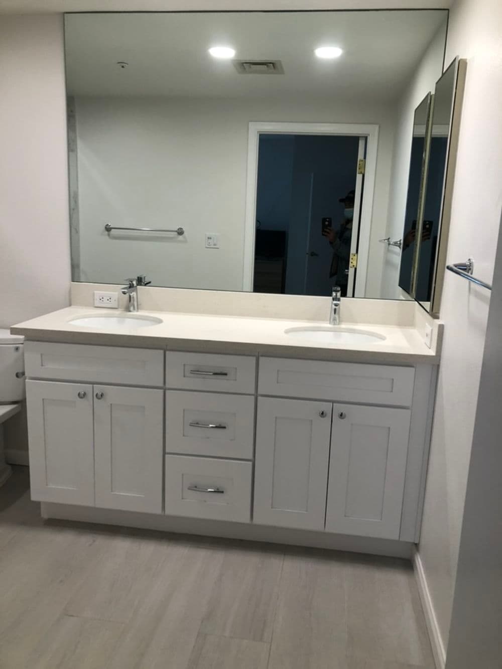 Modern bathroom with white double vanity, two sinks, large mirror, and sleek design.