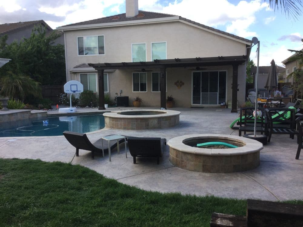 Modern backyard with a pool, spa, and seating area for outdoor relaxation and entertainment.