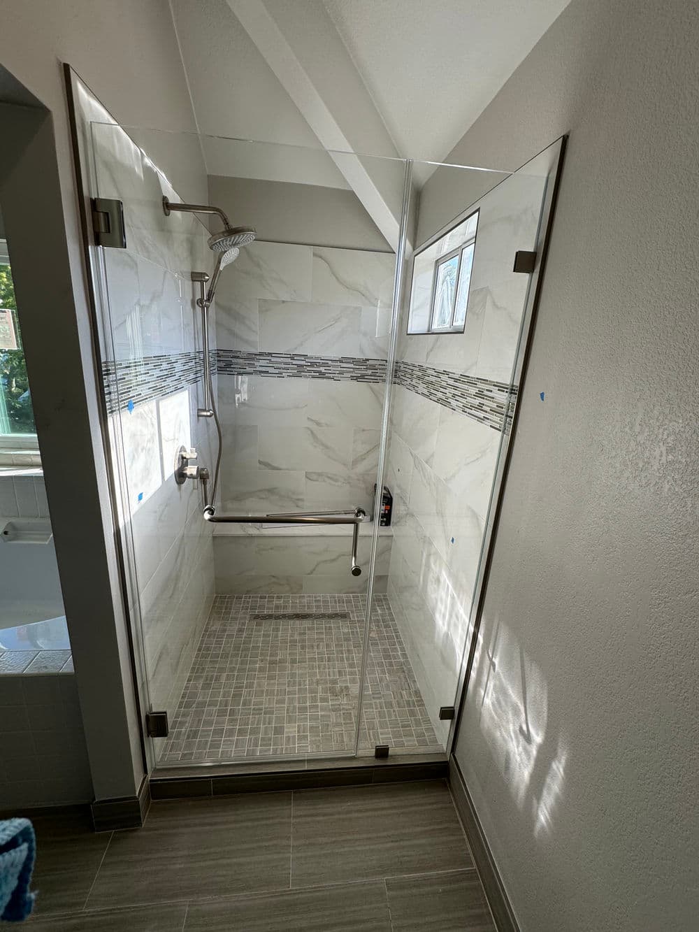 Modern shower design with glass enclosure, decorative tiles, and walk-in access.