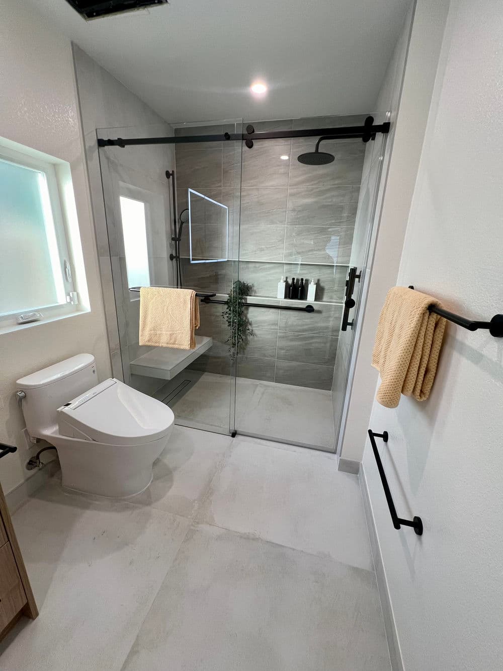 Modern bathroom with glass shower, neutral tiles, and stylish fixtures. Bright and spacious design.