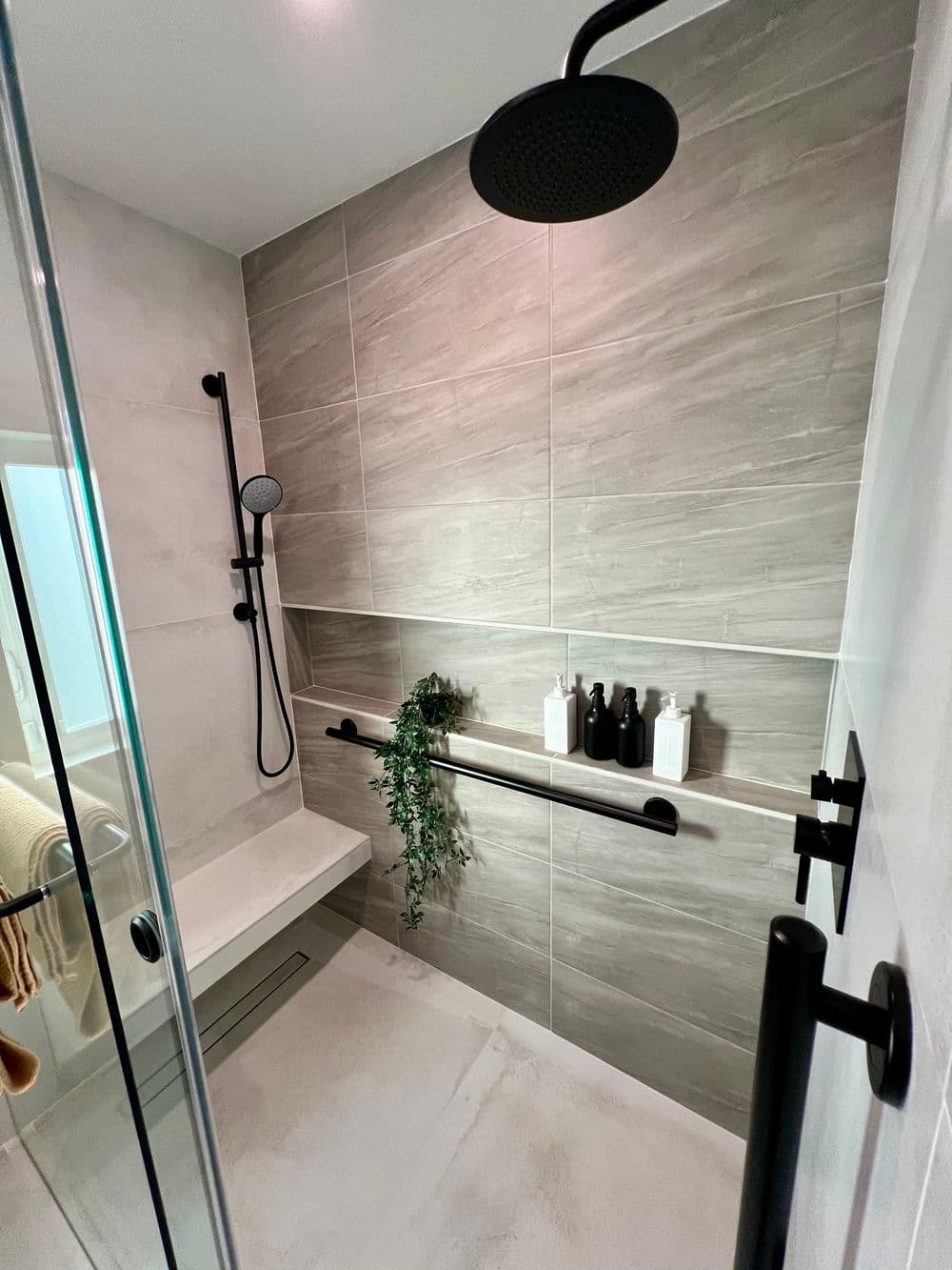 Modern bathroom shower design featuring stylish fixtures, natural elements, and sleek tiles.